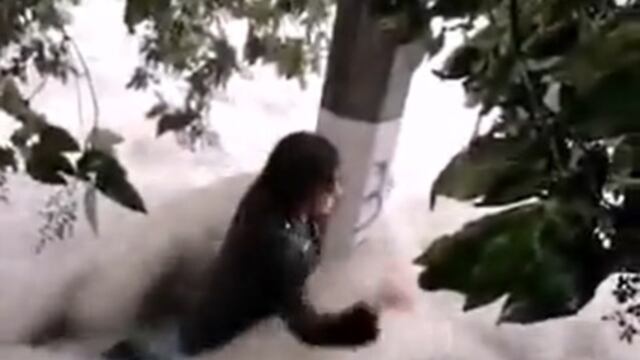 Joven se aferra a poste de luz para no ser arrastrado por corriente de agua