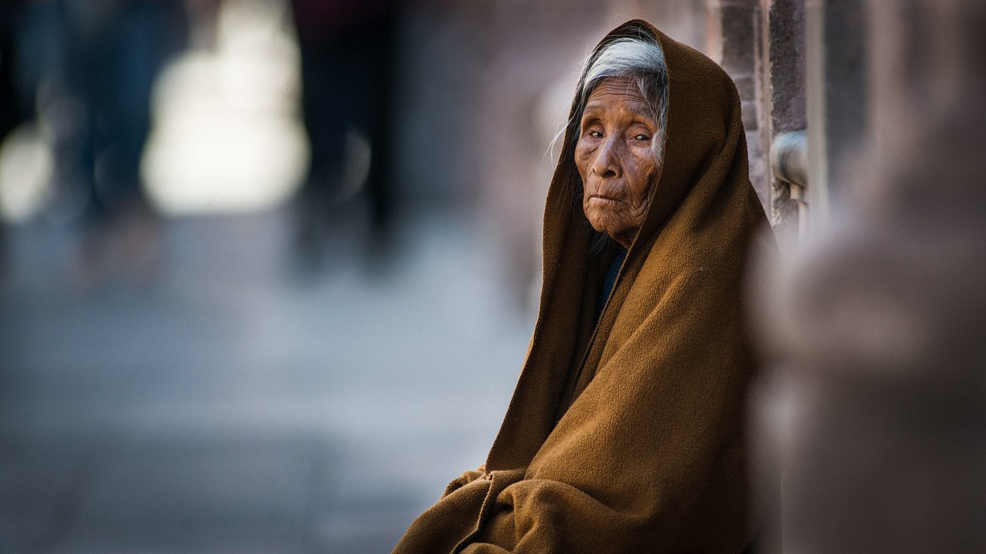 Una anciana de bajos recursos pide limosna