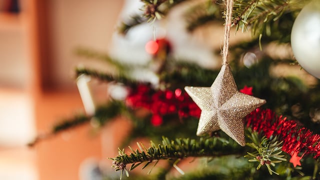 Estrella dorada colgando en un árbol de Navidad.