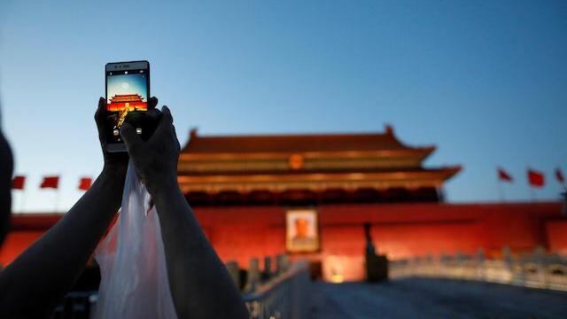 Una turista toma una foto de la Puerta de Tiananmen, en Pekín.