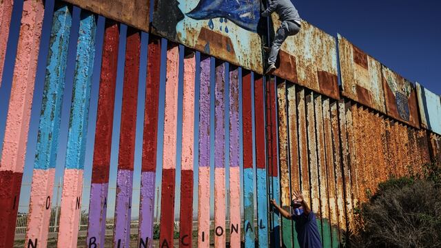 Migrantes intentando saltar muro con Estados Unidos