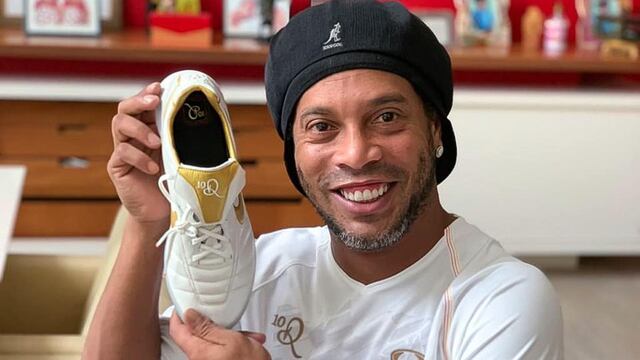 Ronaldinho presume sus zapatos de futbol.