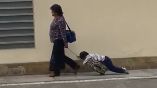 Madre arrastrando a su hijo a la escuela