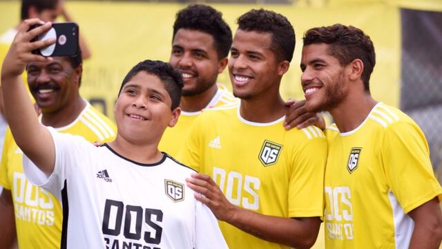 Hermanos Dos Santos y un niño se toman selfie.