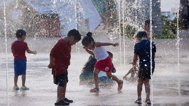 Unos niños combaten el calor jugando en una fuente de la ciudad de Cozumel.