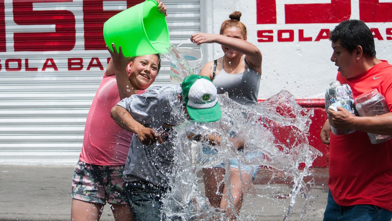 Jóvenes arrojándose agua en Sábado de Gloria. Escasez severa.