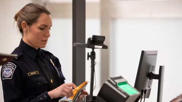 Agente de Estados Unidos revisa pasaportes a turistas que ingresan a este país