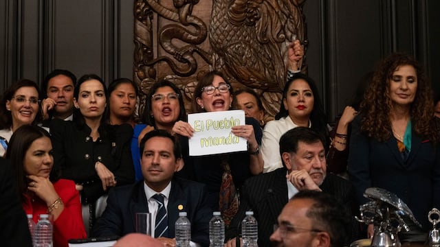 Yeidckol Polevnsky, senadora de Morena, muestra un cartel con la leyenda "El pueblo manda" durante la discusión de la reforma al poder judicial, en la vieja casona de Xicoténcatl