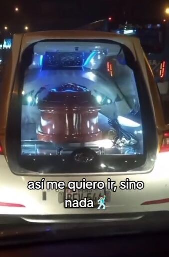 Carroza fúnebre llevando ataúd con todo y fiesta