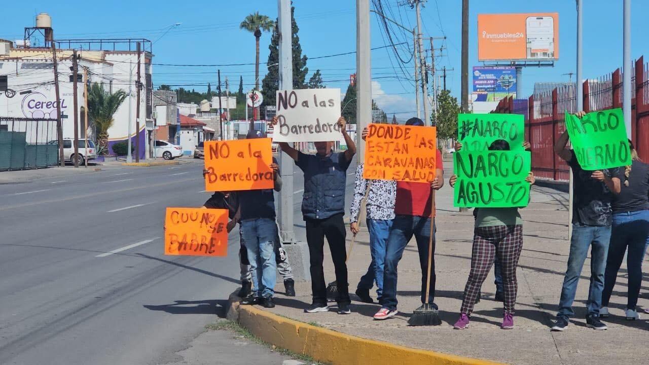 Manifestantes con pancartas de La Barredora y Adán Augusto López en informe de Andrea Chávez