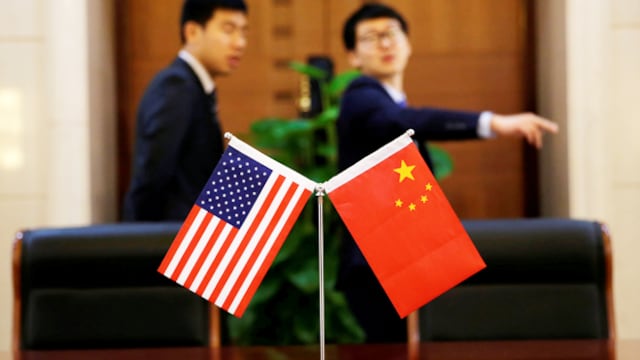 Banderas chinas y estadounidenses durante una ceremonia oficial en Pekín.