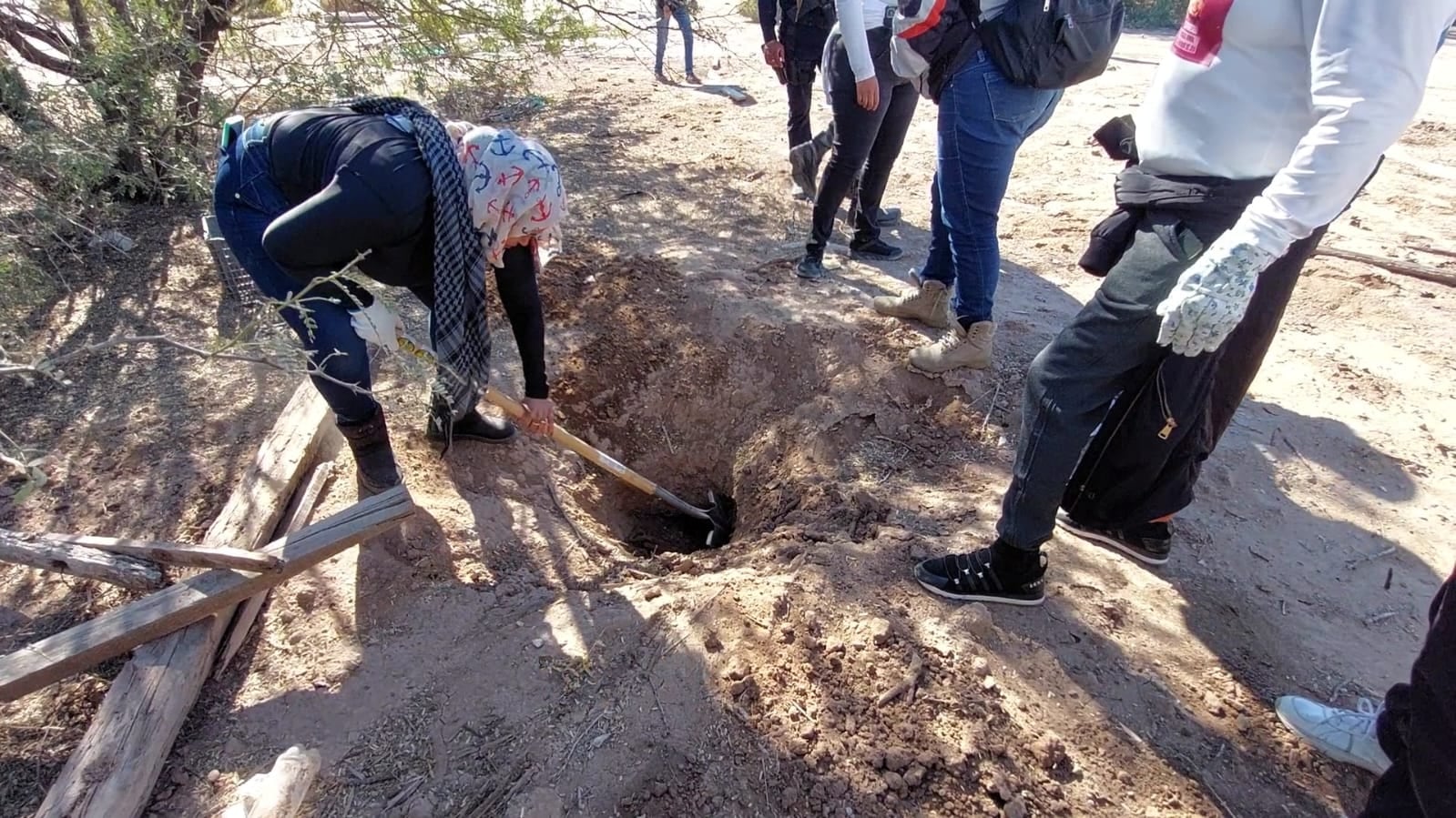 Madres buscadoras cavando en fosa clandestina