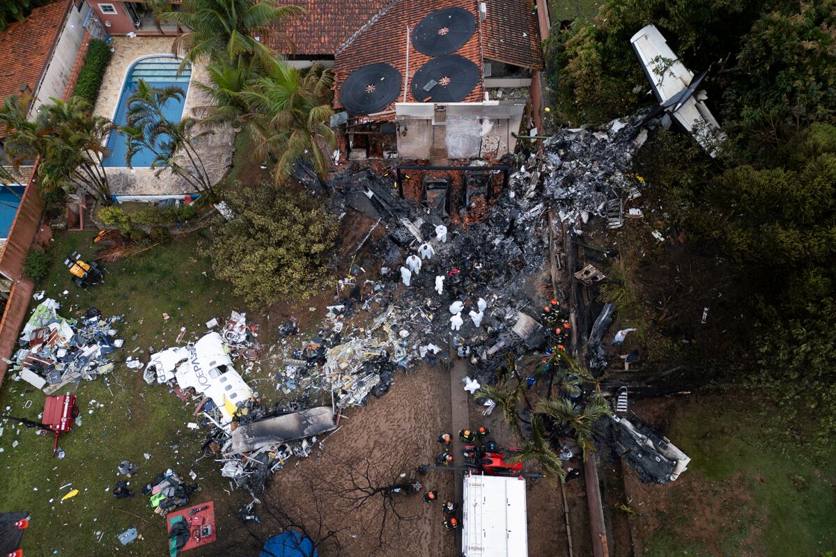 Fotografía aérea que muestra agentes de policía científica de Brasil trabajando este 10 de agosto de 2024, en los restos del fuselaje del avión de la aerolínea Voepass que se estrelló en la ciudad de Vinhedo (Brasil). EFE/ Isaac Fontana