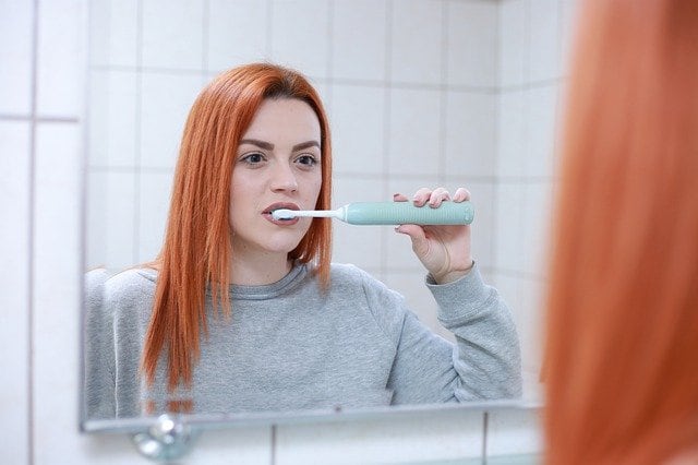 mujer cepillándose los dientes