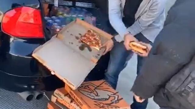 El momento en que un joven reparte pizzas en la calle.