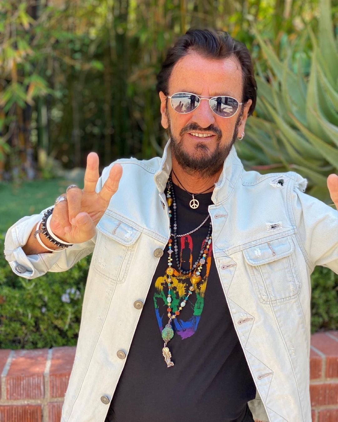 Ringo Starr haciendo su popular 'peace and love' con su mano.