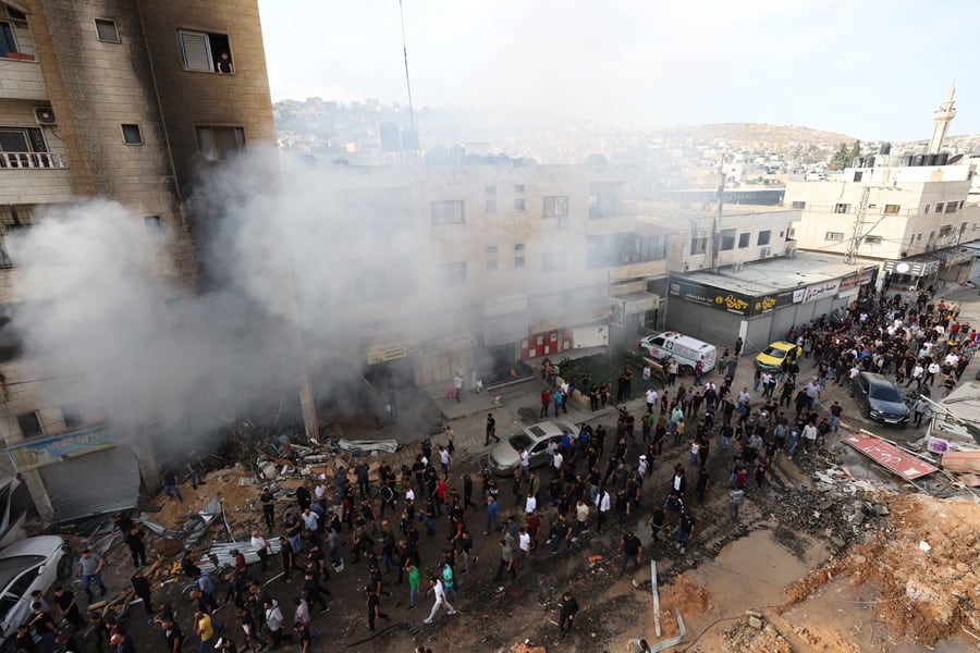 Un grupo de palestinos se concentra junto a un edificio alcanzado en un ataque israelí en Jenin, Cisjordania, este pasado lunes.