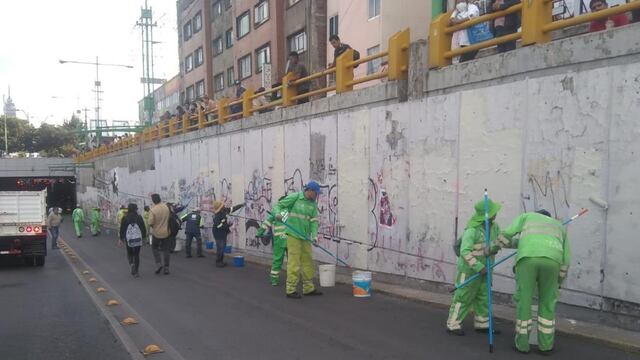 Trabajadores limpiando grafitis