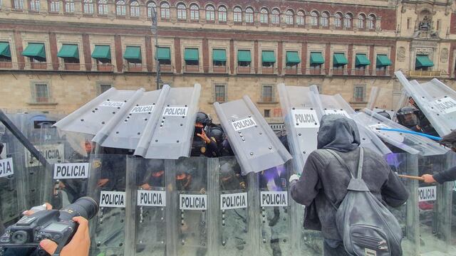 Policías hombres dispersan a manifestantes por el Día de la Mujer