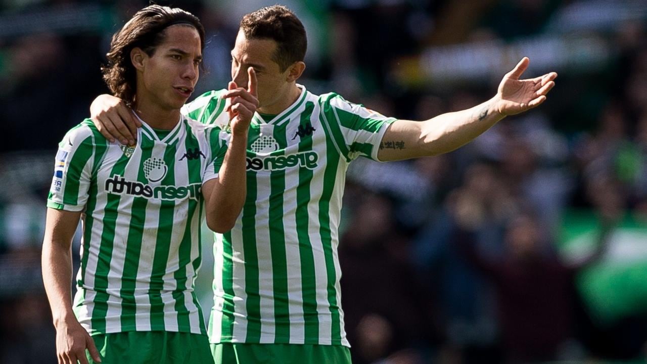 Lainez y Guardado dialogan durante el partido.
