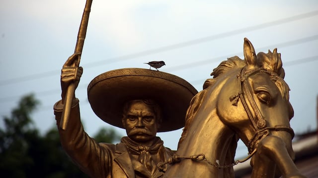 Un ave se posa sobre el filo del sombrero de una estatua del General Emiliano Zapata en la entrada de la ex hacienda de Chinameca