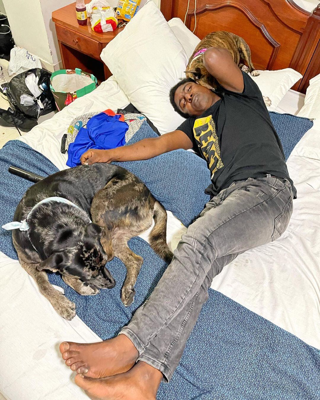 Hombre durmiendo con sus perritos en un refugio