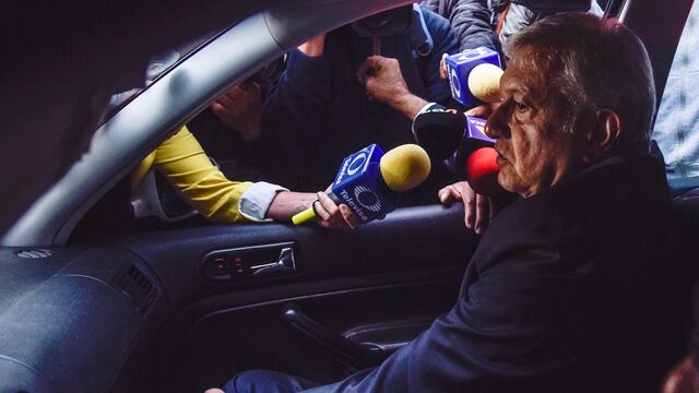 Andrés Manuel López Obrador en su automóvil, rodeado de reporteros, sin escolta.