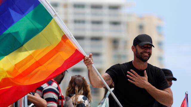 Ricky Martin sostienen una bandera LGBTI durante protestas en San Juan, Puerto Rico