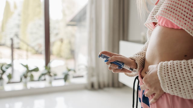 Mujer inyectándose medicamento GLP-1.