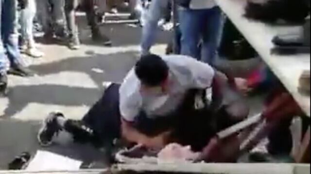 El policía fue derribado sobre estantes de zapatos.