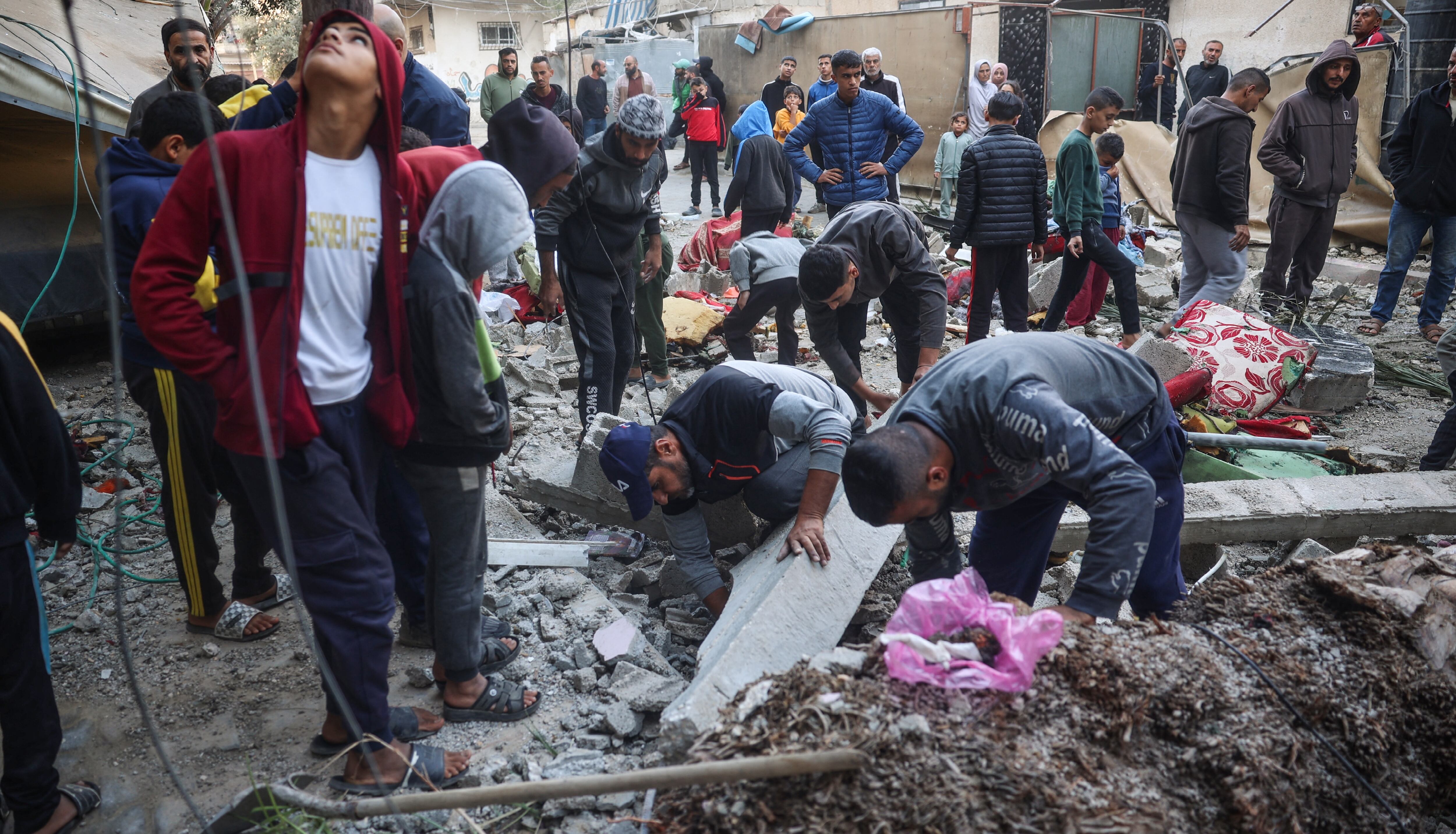 Personas revisan escombros tras bombardeos israelíes en Nuseirat, al centro de Gaza