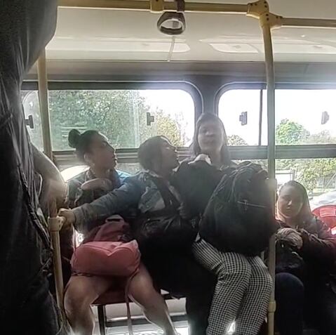 Se sienta en las piernas de otra pasajera