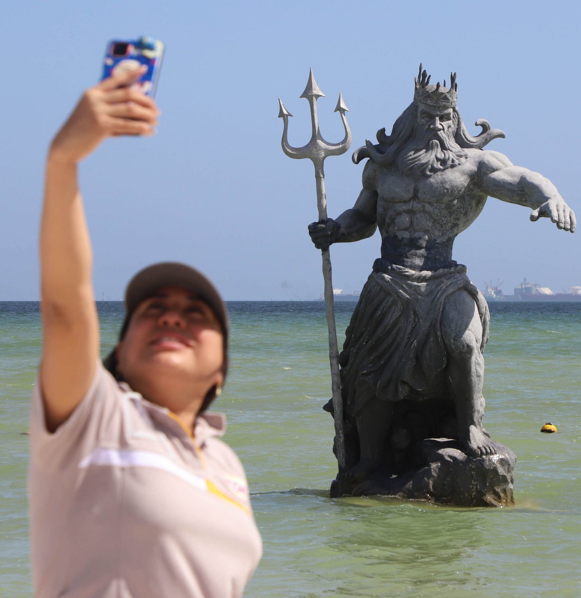 Turistas tomándose fotos con el Poseidón de Progreso