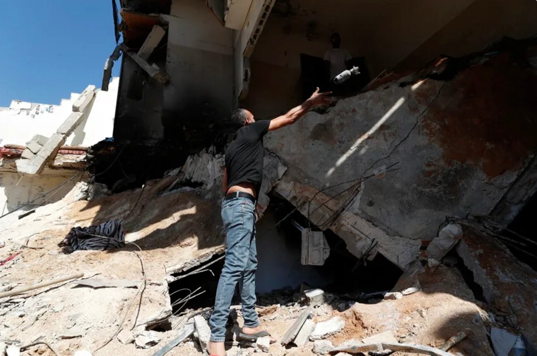 Un palestino lanza un proyectil vacío en el lugar de un ataque militar israelí en el campamento de Nour Shams.