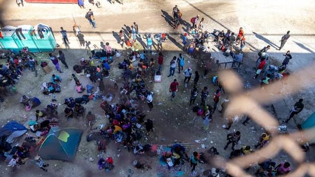 Migrantes acampan bajo puente en la frontera de México con Texas