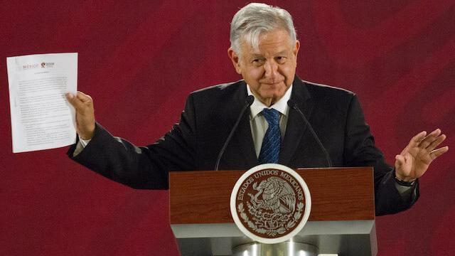 AMLO posa junto a su carta compromiso de no reelección