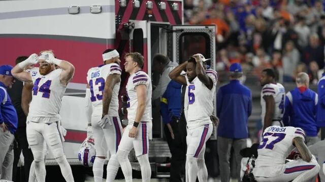 Los jugadores d elos Bills impactados mientras se llevan a Damar Hamlin al hospital.