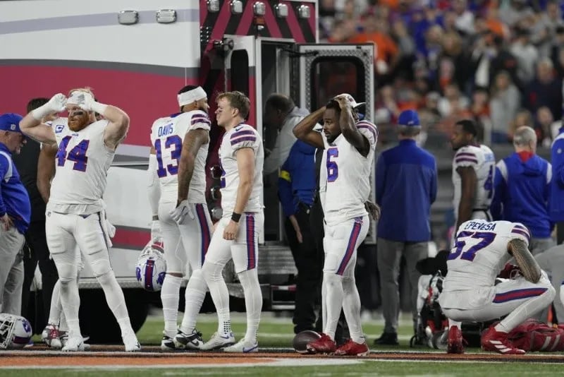 Los jugadores d elos Bills impactados mientras se llevan a Damar Hamlin al hospital.