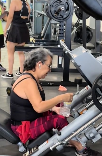 Mujer toma mezcal en el gimnasio