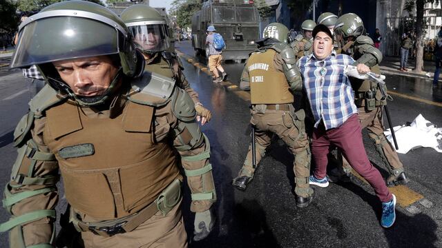 Fuerzas policiales de Chile deteniendo a un manifestante. Protestas por visitas del Papa.