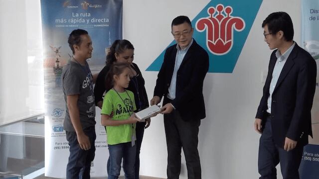 Ejecutivos de la empresa entregan el boleto a Samanta.