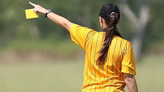 Árbitra señala una falta.