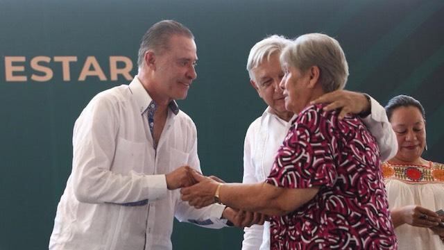 El gobernador y el presidente López Obrador saludan a una beneficiaria de programas sociales.