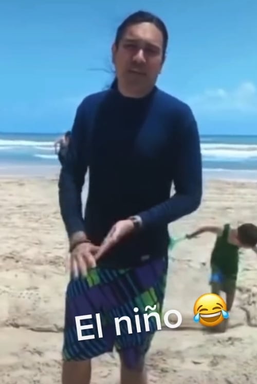 Niño destruyendo cocodrilo de arena, mientras artista explica su obra