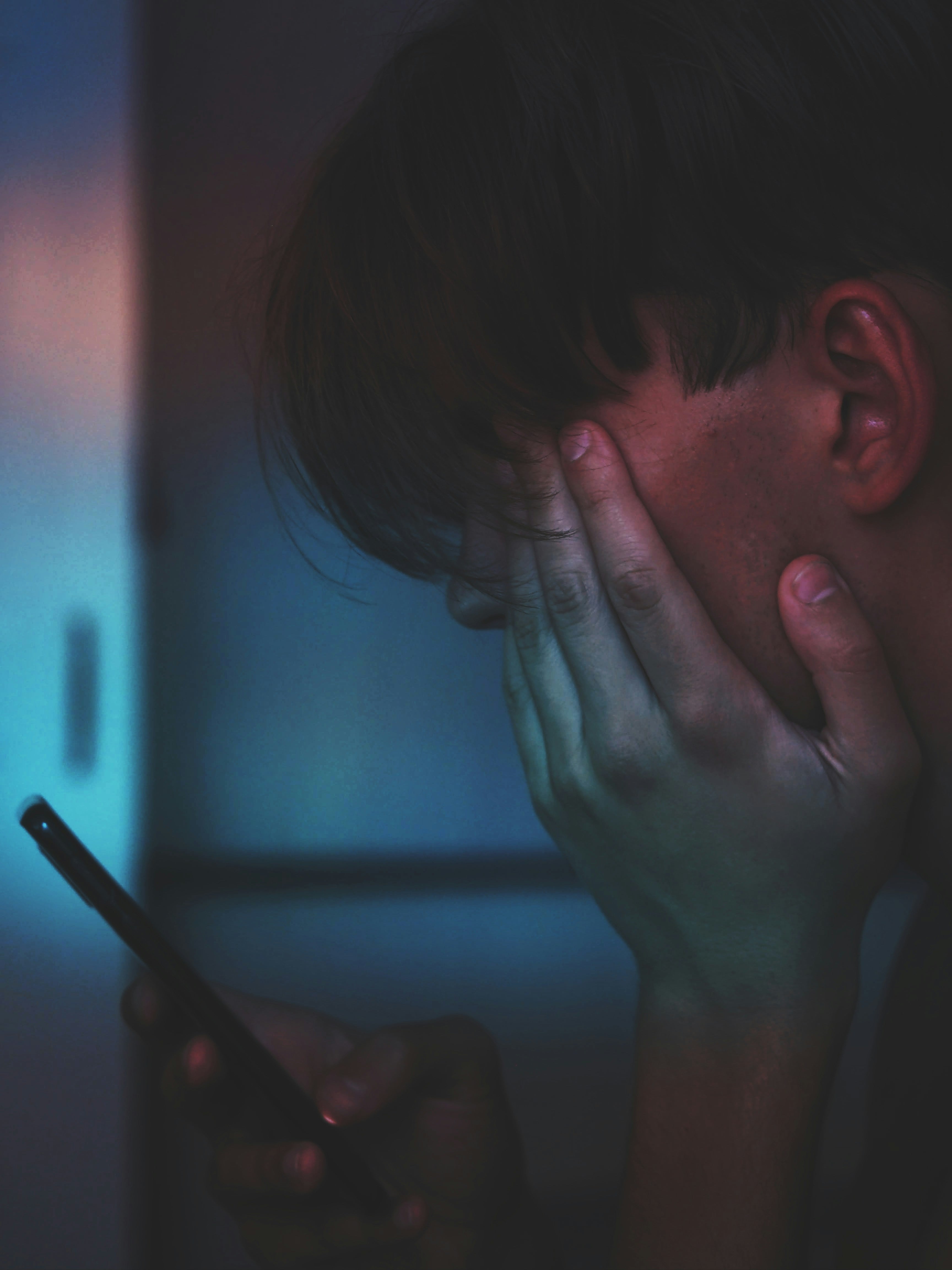 Hombre viendo su celular en la noche