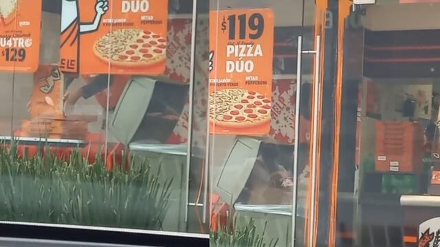 Empleado de Little Caesars sacando cajas de pizza de las basura
