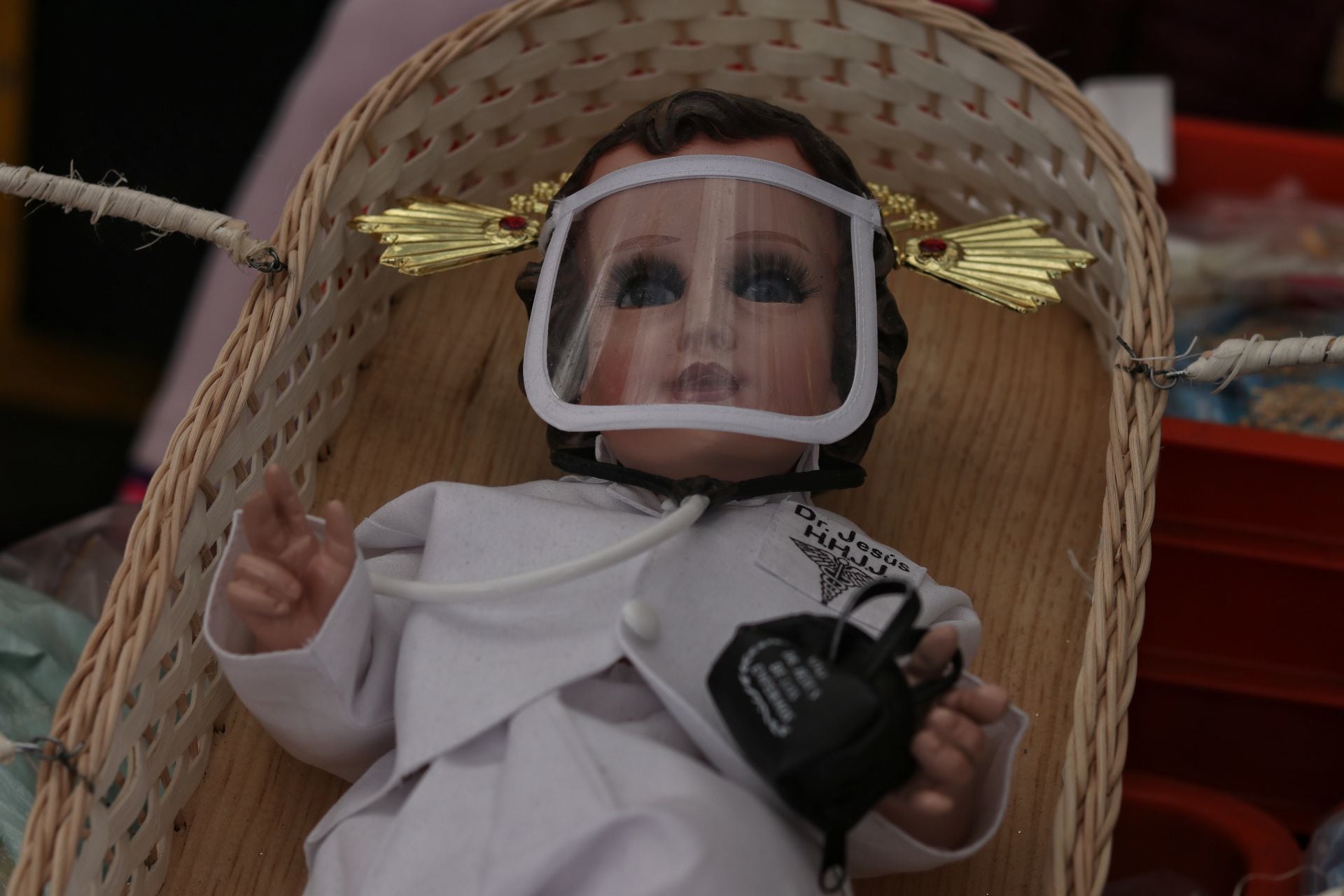 Niño dios vestido de doctor en un cesto