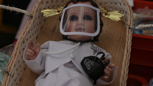 Niño dios vestido de doctor en un cesto