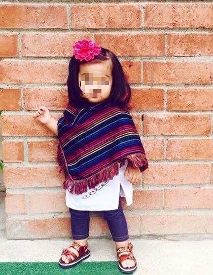 Niña vestida con sarape de colores