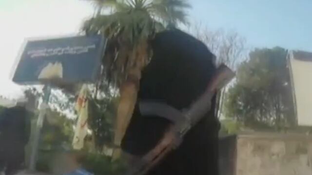 (YouTube) Mujer armada camina en Siria acompañada de un menor